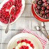 A pudding with freshly cooked cherry compote stands on a plate by Edith Albuschat