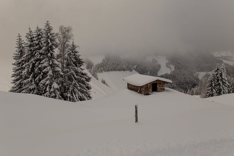 Cabane de montagne dans la neige vue du sommet nuageux par Guido Akster