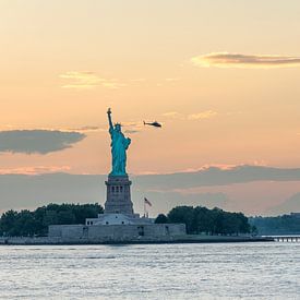 The Statue of Liberty in New York during a warm sunset by Carlos Charlez