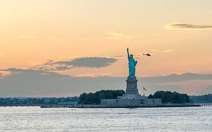 Het Vrijheidsbeeld in New York tijdens een warme zonsondergang van Carlos Charlez