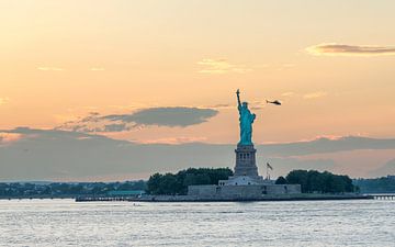 Het Vrijheidsbeeld in New York tijdens een warme zonsondergang van Carlos Charlez