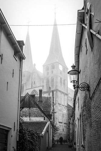 The Bergkerk in Deventer Overijssel Netherlands in the mist with a pedestrian in the foreground.