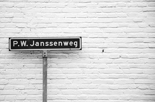 'P.W. Janssenweg' straatnaambord in Jubbega, zwart-wit foto.