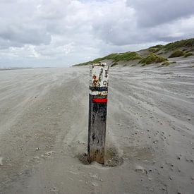 Verweerde strandpaal met verlaten strand van Folkert Jan Wijnstra