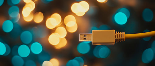Gele USB-kabel tegen een lichtgevende achtergrond