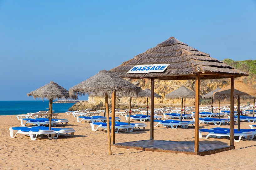 Rieten parasols en strandbedden op het strand aan de kust in Albufeira in Portugal par Ben Schonewille