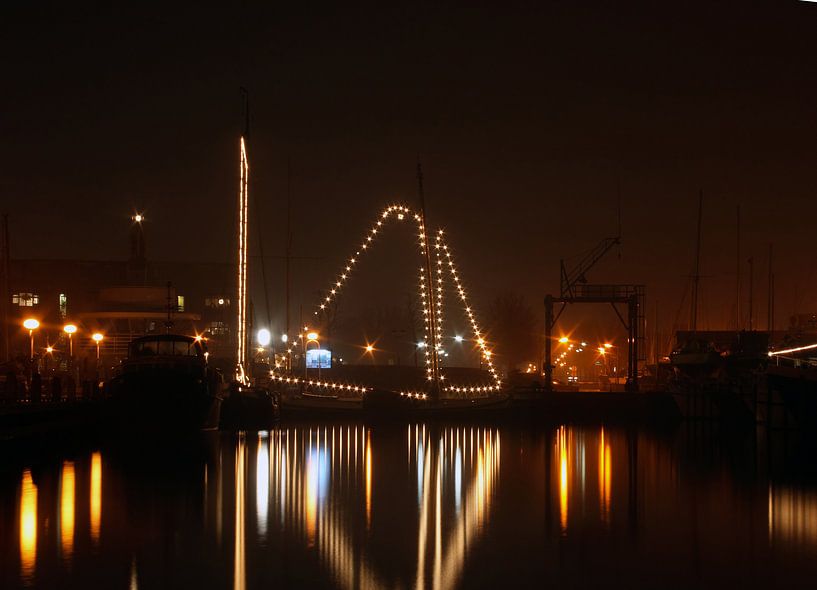 Beleuchtetes Segelboot im Hafen von Huizen in den Niederlanden bei Nacht von Eye on You