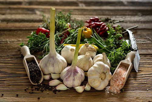 Verse knoflook met kruiden op rustiek hout