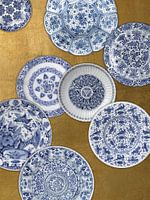 Verzameling Delfts blauwe borden op gouden achtergrond, Rijksmuseum