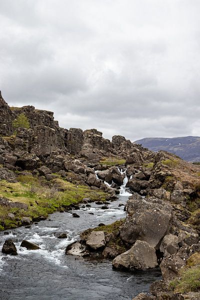 Landscape with flowing water between rocks in Iceland | Travel photography by Kelsey van den Bosch