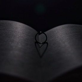Foto eines Rings auf einem Buch, das ein Herz bildet von Bram Jansen