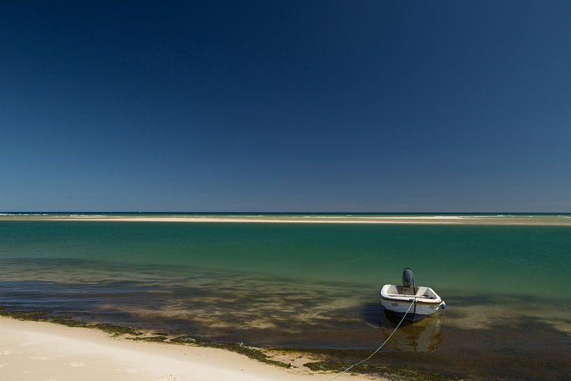 Plage de blanc brillant avec la mer bleue et le ciel un bateau au Portugal par Arjan Groot