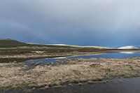 Noors aangelicht berglandschap met water en donkere lucht