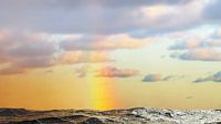 Regenboog over de zee