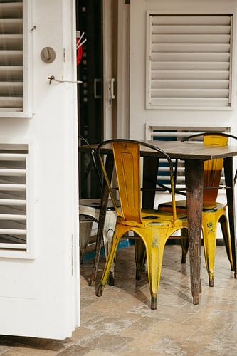 Chaises classiques en acier jaune sur une terrasse ensoleillée à Willemstad, Curaçao