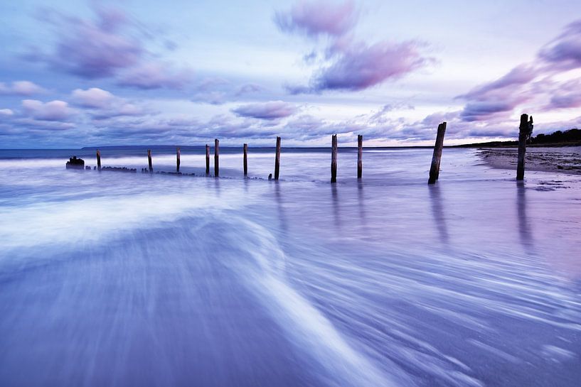Poteaux en bois sur la plage de la mer Baltique à la lumière du soir sur Ralf Lehmann