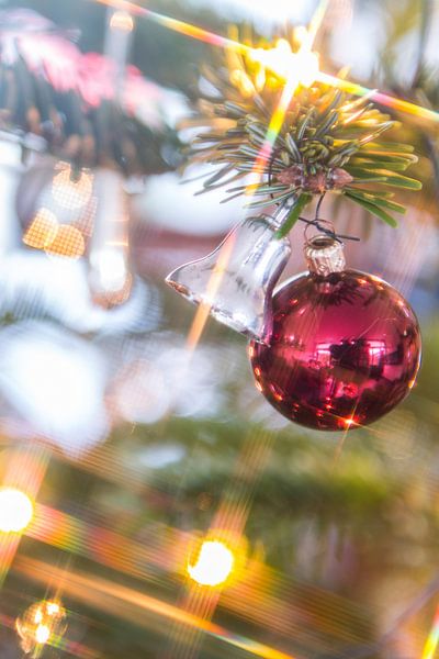 Zilverkleurig kerstklokje en rode kerstbal van Wim Stolwerk
