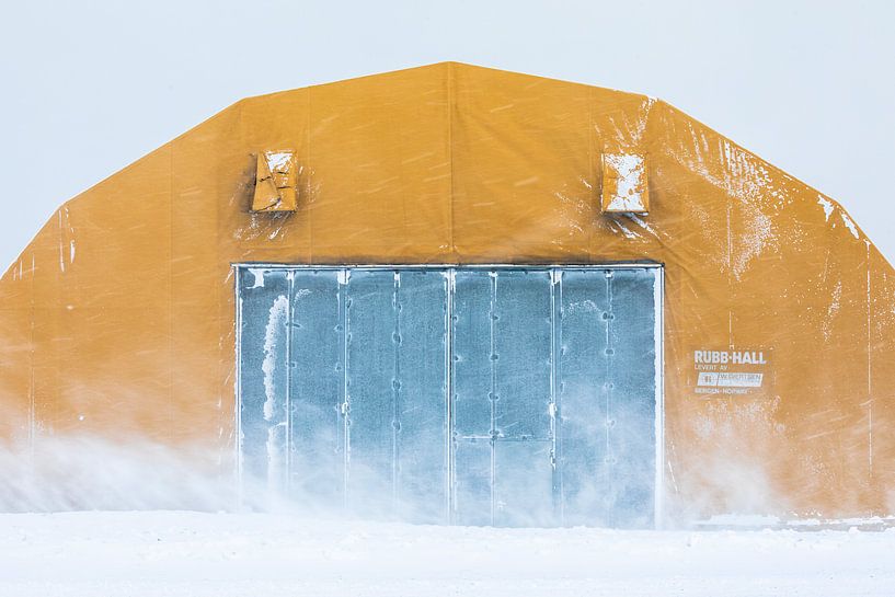 Yellow Rubb Hall in the snow on Spitsbergen by Martijn Smeets