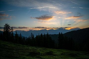 s Morgens komen zonnestralen van achter de Alpen tevoorschijn van chamois huntress