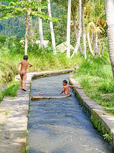 Twee kindjes spelen in de rivier in Bali