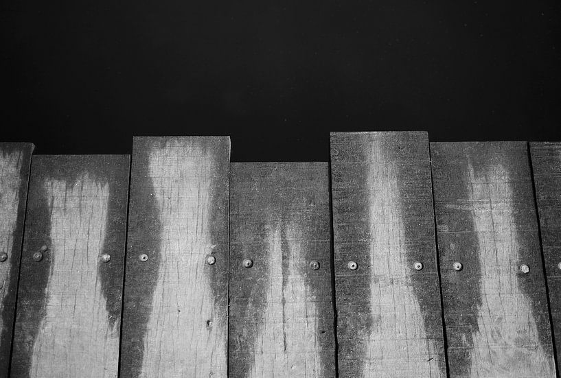 Planken van de brug in zwart-wit von Anne van de Beek