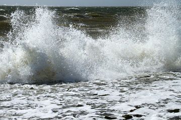 Opspattende golven tijdens een storm op de noordzee kust