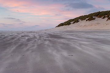 Stuifzand op het strand met een roze lucht van Paul Veen