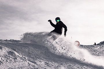 Snowboarder maakt spray op de Hintertux Gletjer in Oostenrijk