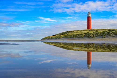 Texel lighthouse at the beach during a calm autumn afternoon wit