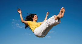 Een vrolijke sprong in de lucht tegen de blauwe hemel