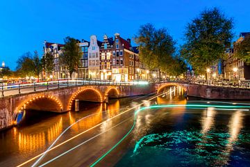 Lichstrepen op de Amsterdamse grachten bij nacht