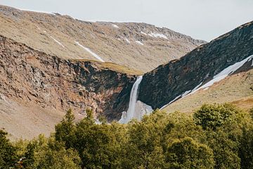 Großer Wasserfall in den Bergen von Norwegen, Skandinavien, umgeben von Bäumen und Schnee.