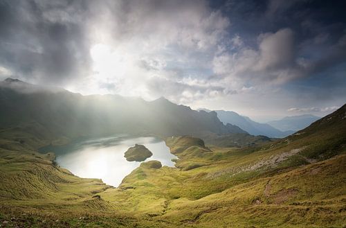 sunlight through clouds over alpine lake