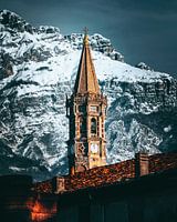 Majestueuze klokkentoren tegen besneeuwde bergen