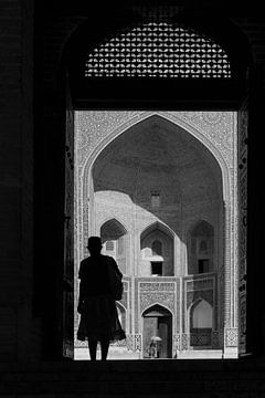 Vrouw in deuropening madrassa Bukhara