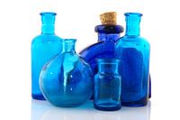 Several blue glass objects in a row isolated over white