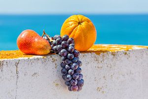 Fresh fruit lies on white wall in front of blue sea sur Ben Schonewille