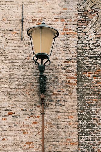 Oude lamp op een rode bakstenen muur in Elburg