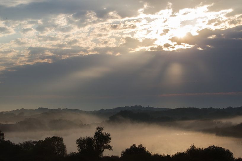 Zon door wolken boven mist duinlandschap van Menno van Duijn