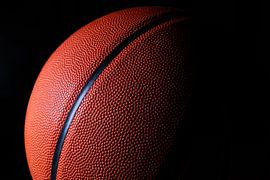 Close-up of a basketball against a black background by Pamela Uyttendaele