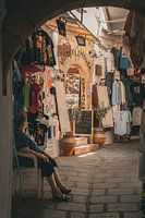 Vieille dame à l'ombre pour se rafraîchir dans un magasin touristique