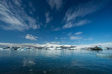 Island - Blauer Himmel mit Sonne über schmelzendem Eis eines Gletschersees von adventure-photos