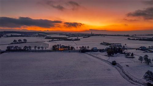 Zonsondergang in een besneeuwd Zuid-Limburg van John Kreukniet