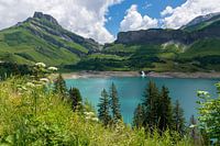 Lac de montagne bleu avec des montagnes vertes et une chute d'eau