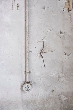 Ouderwets stopcontact aan een beschadigde muur in een verlaten schoolgebouw van Sjoerd van der Wal