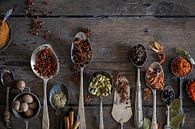 Spices on an old wooden table table by Saskia Schepers thumbnail