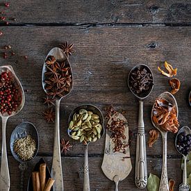Spices on an old wooden table table by Saskia Schepers