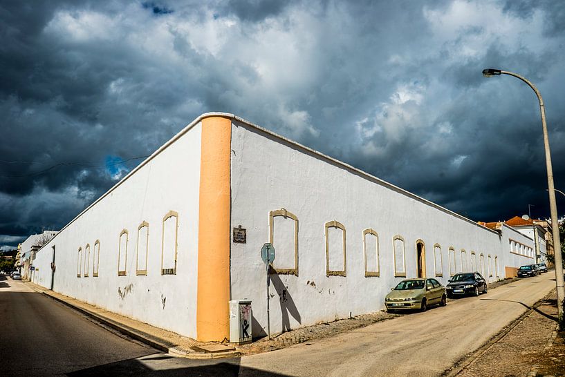 Weißes Gebäude mit dunklen Wolken von Fred Leeflang