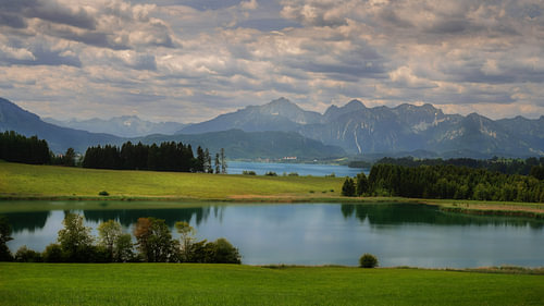 De Forggensee voor de Allgäuer Alpen in het licht van de wolken