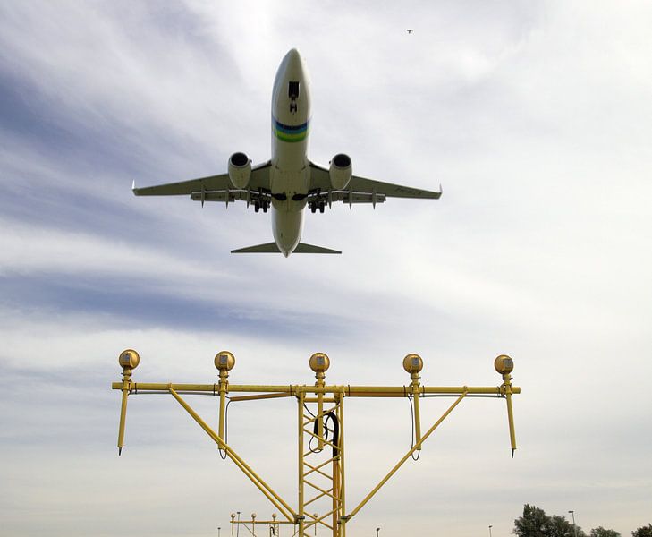 Das Transavia-Flugzeug landet am Flughafen Rotterdam Den Haag über einer hellen Leiste der Startbahn von André Muller